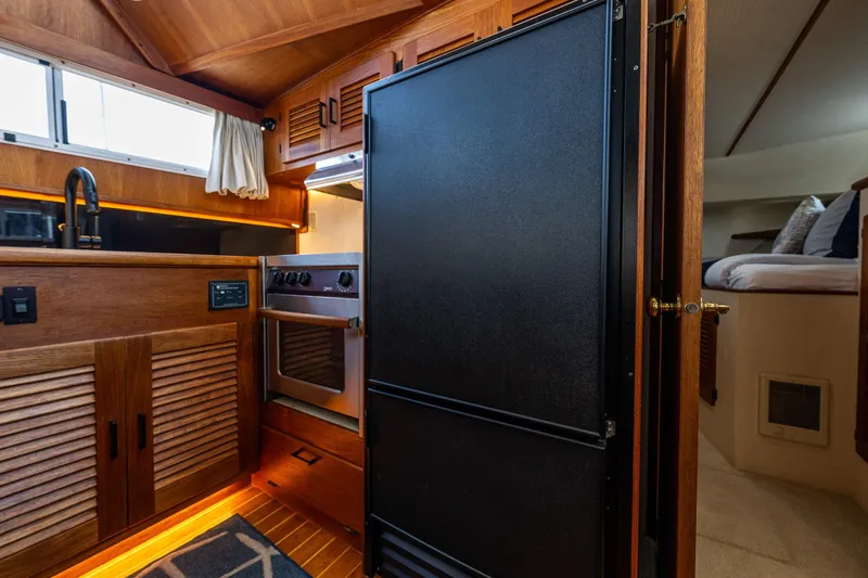 Holiday Yacht Photos Pics 1991 Tollycraft 48 Cockpit Motor Yacht interior with kitchen and cozy bedroom.