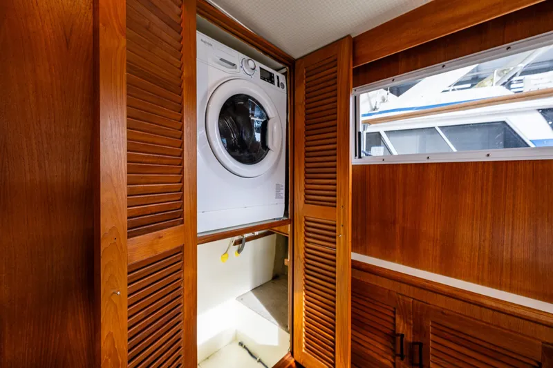 Holiday Yacht Photos Pics Laundry area in 1991 Tollycraft 48 Cockpit Motor Yacht with wooden cabinetry.