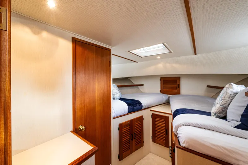 Holiday Yacht Photos Pics Interior of 1991 Tollycraft 48 Cockpit Motor Yacht with cozy twin beds and wooden accents.