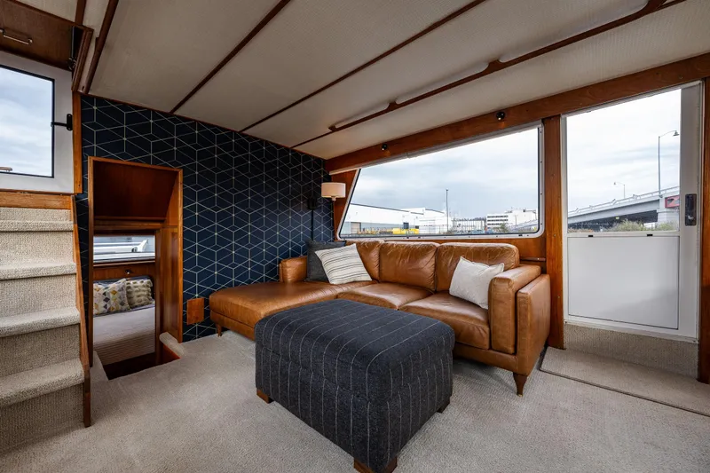 Holiday Yacht Photos Pics Luxurious interior of 1991 Tollycraft 48 Cockpit Motor Yacht with leather sofa and geometric wall design.