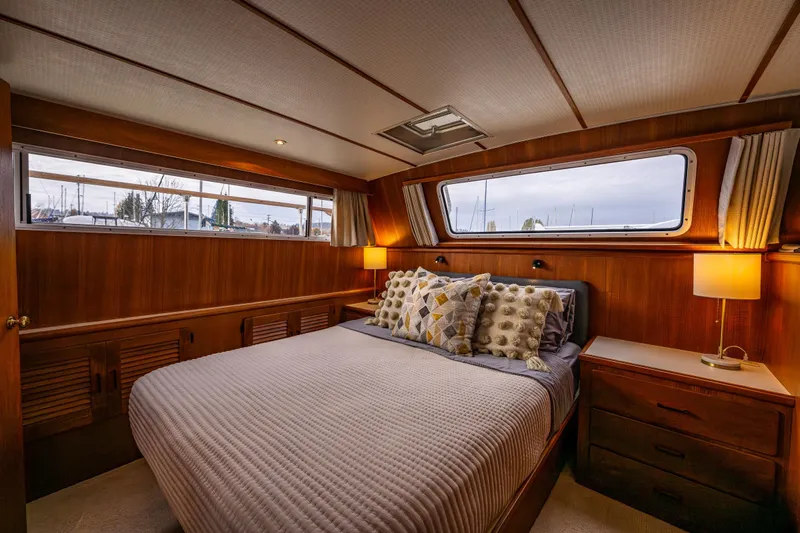 Holiday Yacht Photos Pics Luxurious bedroom interior of 1991 Tollycraft 48 Cockpit Motor Yacht with elegant wood finish.