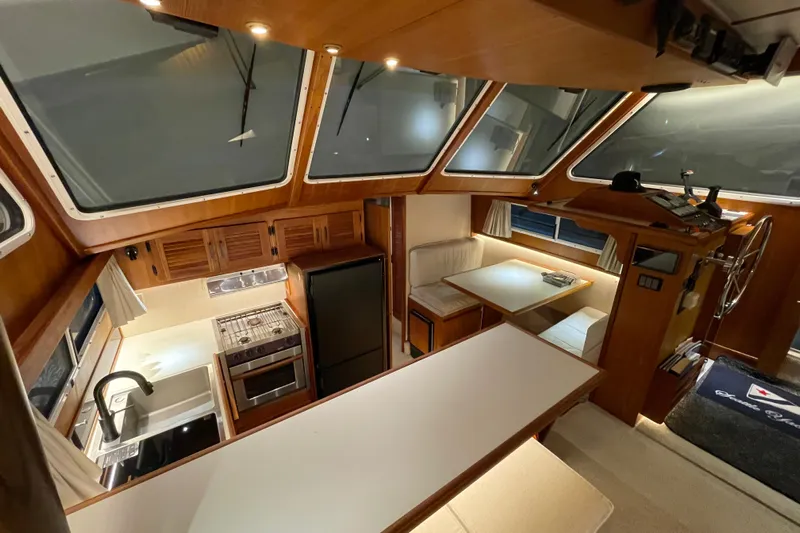 Holiday Yacht Photos Pics 1991 Tollycraft 48 Cockpit Motor Yacht interior with kitchen, dining area, and helm station.