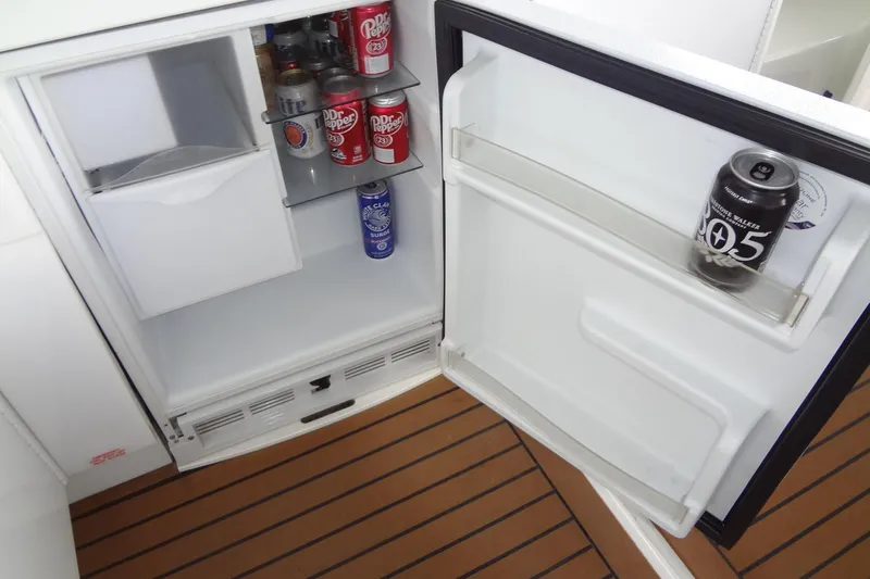 Dream Catcher Yacht Photos Pics Open mini fridge on 2010 Formula 45 Yacht, stocked with beverages on wooden flooring.