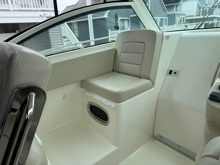 Yacht Photos Pics 2019 Boston Whaler 315 Conquest interior seating with beige upholstery and window view.