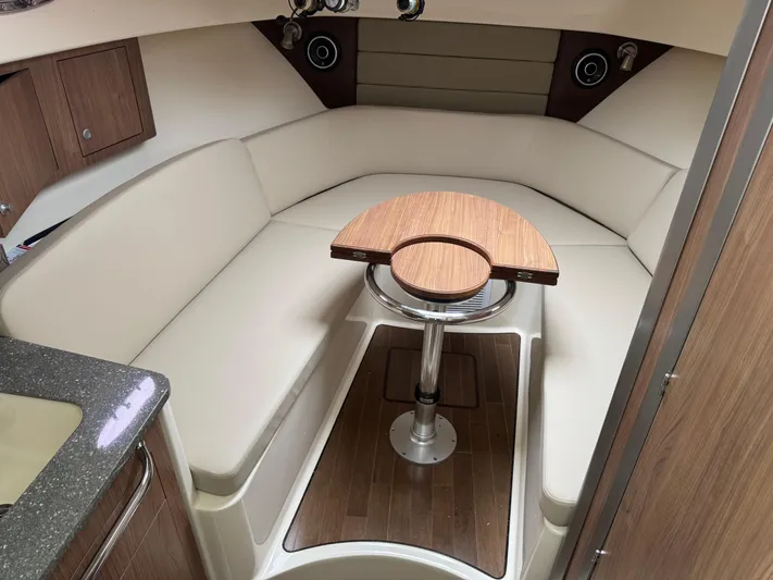  Yacht Photos Pics 2019 Boston Whaler 315 Conquest cabin interior with seating and wooden table.