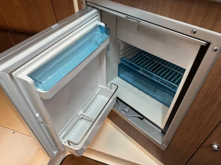  Yacht Photos Pics Open refrigerator inside 2019 Boston Whaler 315 Conquest boat, showcasing storage compartments.