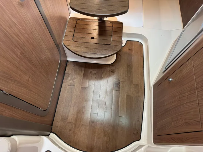 Yacht Photos Pics 2019 Boston Whaler 315 Conquest interior with wooden flooring and compact seating.