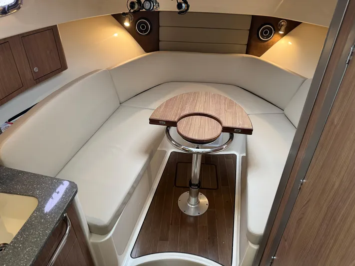  Yacht Photos Pics 2019 Boston Whaler 315 Conquest cabin interior with seating and wooden table.