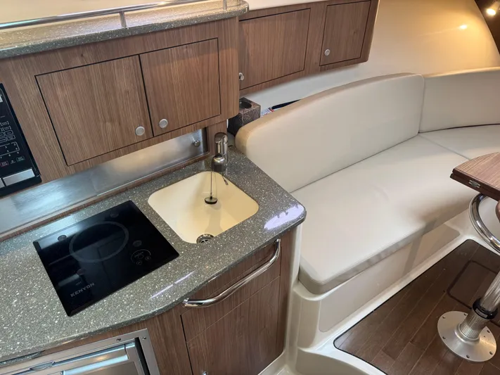 Yacht Photos Pics 2019 Boston Whaler 315 Conquest interior with kitchenette and seating area.