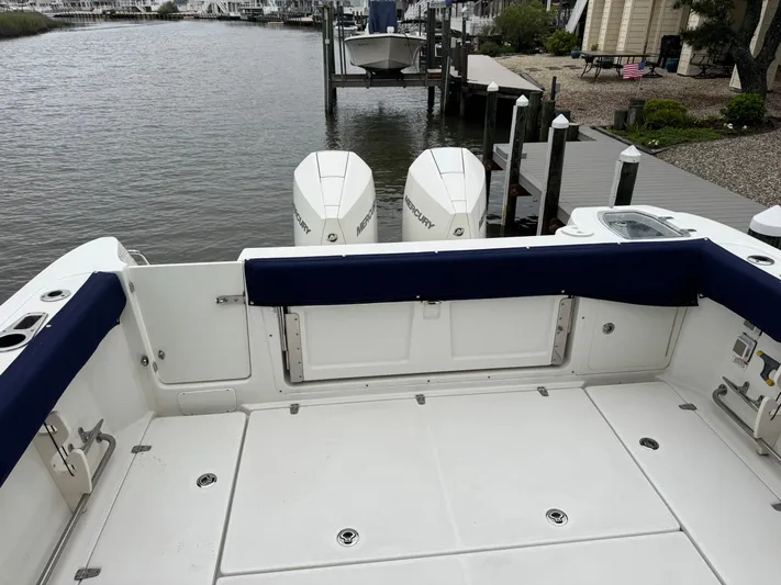  Yacht Photos Pics 2019 Boston Whaler 315 Conquest boat deck with twin outboard engines at a dock.