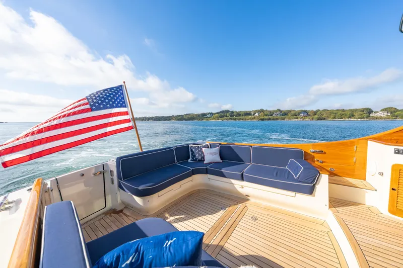 Virginia Yacht Photos Pics Hinckley Talaria 48 Flybridge 2013 yacht with American flag, blue seating, and scenic ocean view.