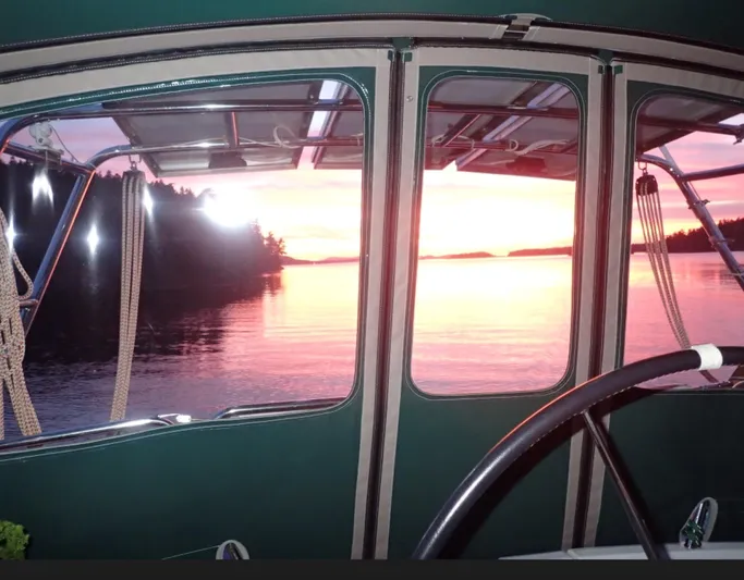 Rarebird Yacht Photos Pics Beneteau 393 sailboat cockpit view at sunset, 2004 model, serene water and vibrant sky.