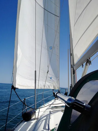 Rarebird Yacht Photos Pics Sailing on a 2004 Beneteau 393 yacht with white sails against a clear blue sky.
