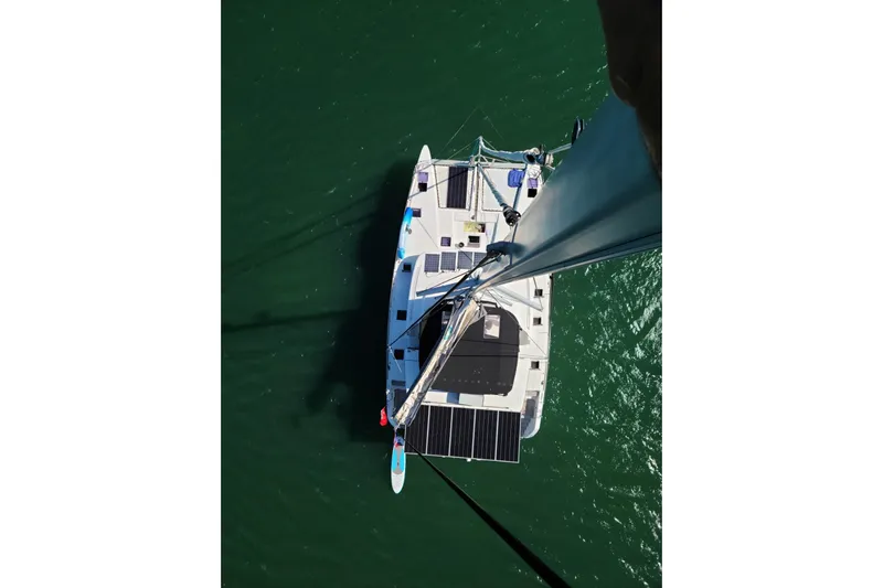 Sami Malu Yacht Photos Pics Aerial view of 2017 Lagoon 52 F catamaran with solar panels on green water.