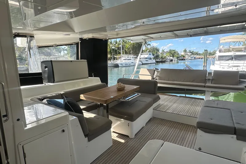 Sami Malu Yacht Photos Pics Luxurious 2017 Lagoon 52 F yacht interior with elegant seating and scenic marina view.