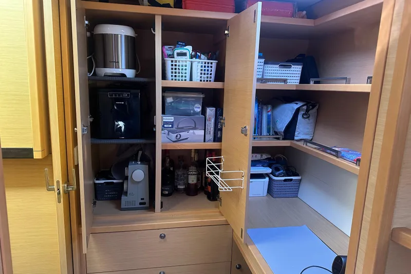 Sami Malu Yacht Photos Pics Cabinet interior on 2017 Lagoon 52 F yacht, featuring organized kitchen appliances and storage baskets.