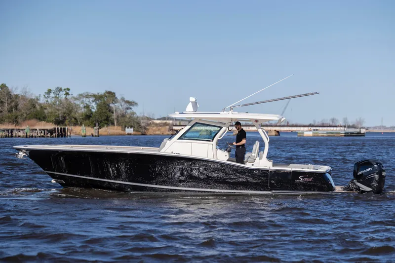  Yacht Photos Pics 2019 Scout 355 LXF boat cruising on a sunny day with a person onboard.