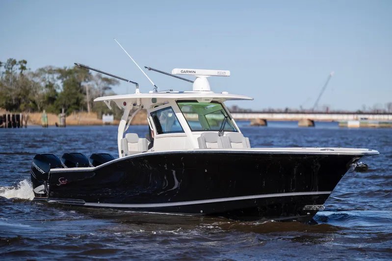  Yacht Photos Pics 2019 Scout 355 LXF boat cruising on a river with clear skies.