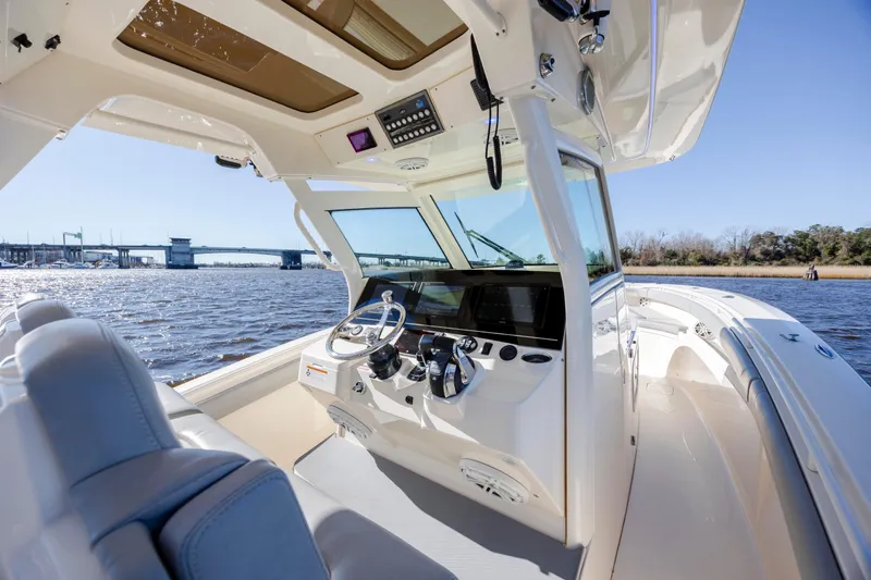  Yacht Photos Pics 2019 Scout 355 LXF boat interior with helm, steering wheel, and water view.