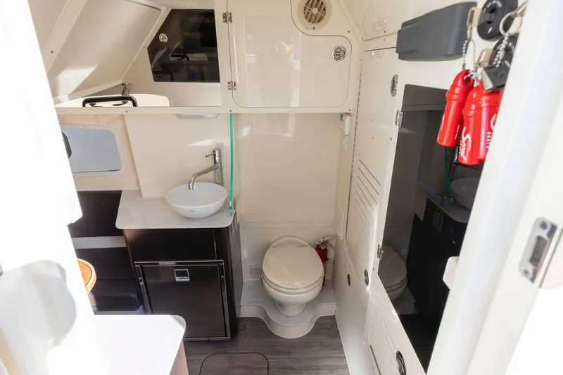  Yacht Photos Pics 2019 Scout 355 LXF boat interior with sink, toilet, and storage cabinets.