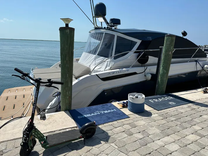  Yacht Photos Pics 2021 Azimut Atlantis 45 yacht docked by the sea with a scooter nearby.