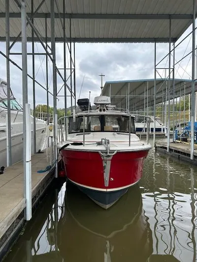  Yacht Photos Pics 2023 Ranger Tugs R23 boat docked in a marina, featuring a vibrant red hull.