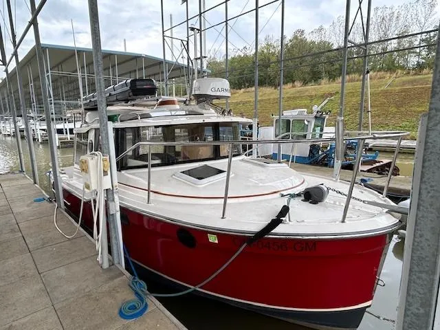  Yacht Photos Pics 2023 Ranger Tugs R23 boat docked in a marina, featuring a vibrant red hull.