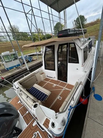  Yacht Photos Pics 2023 Ranger Tugs R23 boat docked, featuring spacious deck and seating area under a covered marina.