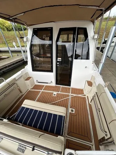  Yacht Photos Pics 2023 Ranger Tugs R23 boat interior with teak flooring and cushioned seating.