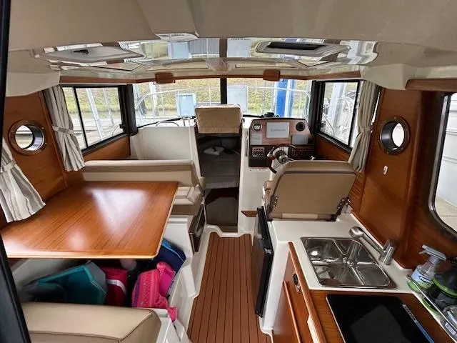  Yacht Photos Pics 2023 Ranger Tugs R23 interior with wood accents, dining area, and helm station.