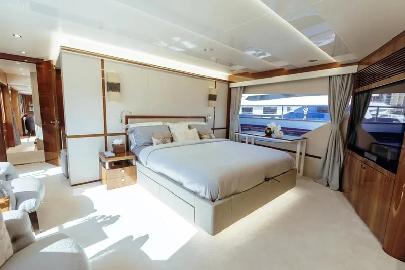  Yacht Photos Pics Luxurious bedroom interior of 2018 Sunseeker 95 Yacht with elegant furnishings and large window.