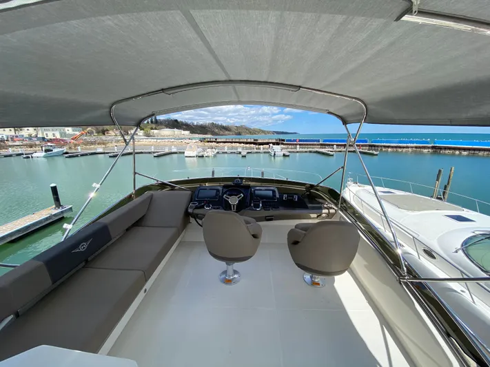 Inconseavable Yacht Photos Pics 2014 Marquis 500 Sport Bridge yacht docked with ocean view.