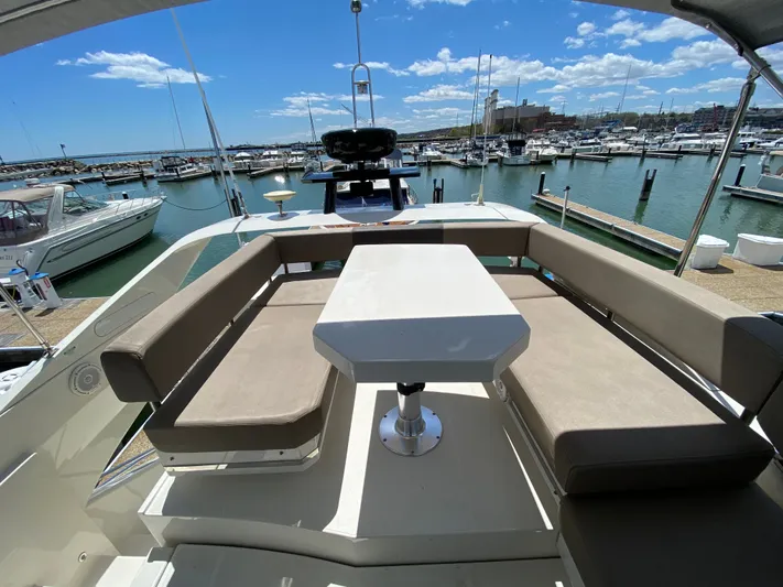 Inconseavable Yacht Photos Pics 2014 Marquis 500 Sport Bridge with seating area in marina.