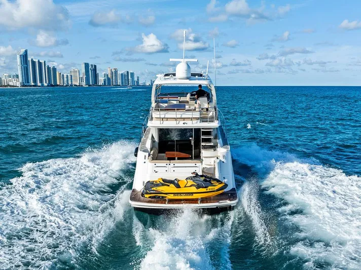  Yacht Photos Pics Sea Ray 510 Fly 2015 yacht cruising near city skyline, with jet ski on deck.