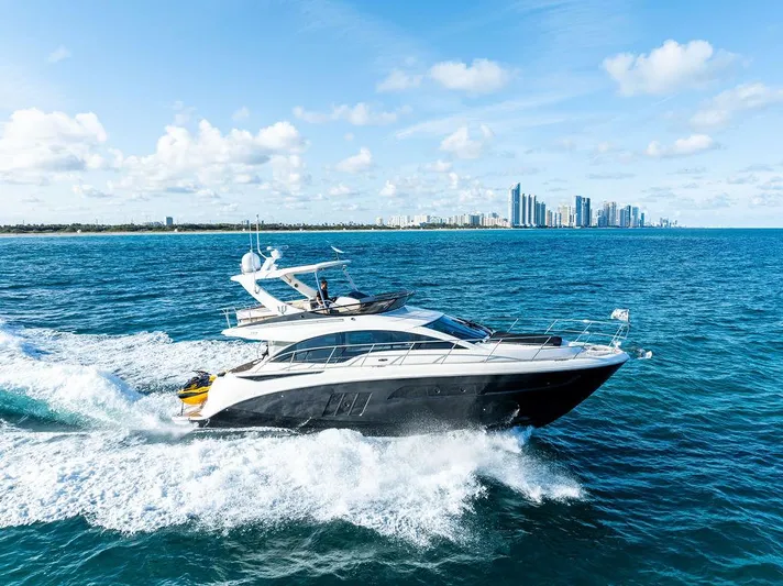  Yacht Photos Pics 2015 Sea Ray 510 Fly yacht cruising on blue ocean with city skyline in background.
