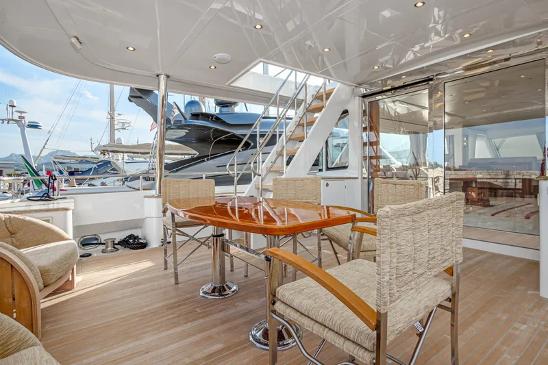 Frivolous Yacht Photos Pics 2019 Hunt Yachts Motor Yacht with elegant outdoor seating and polished wood table.