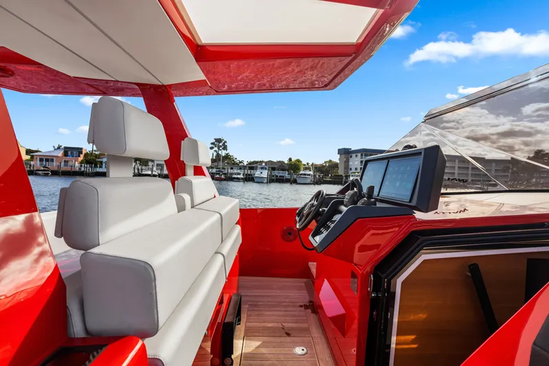 Corso Red Yacht Photos Pics Red 2021 Wally 48ft yacht interior with modern helm and seating, docked by waterfront homes.