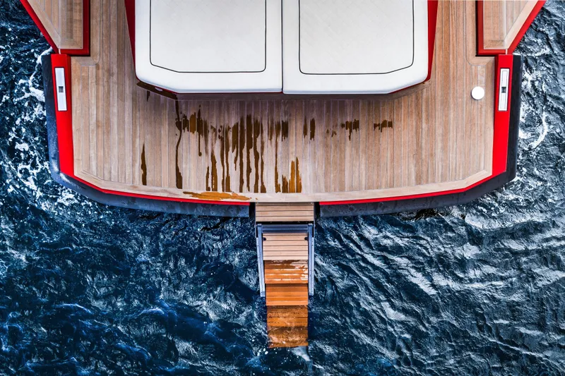 Corso Red Yacht Photos Pics Top view of 2021 Wally 48ft yacht with wooden deck and ocean backdrop.