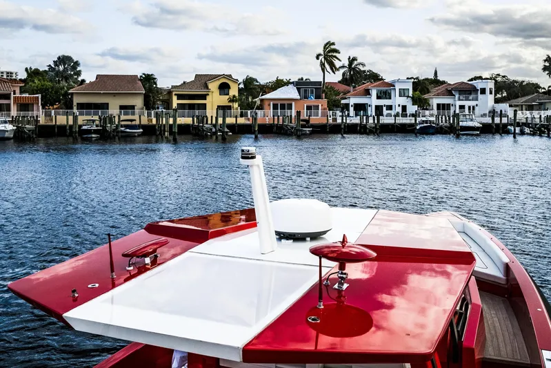 Corso Red Yacht Photos Pics Red Wally 48ft yacht on water, 2021 model, with waterfront homes in background.