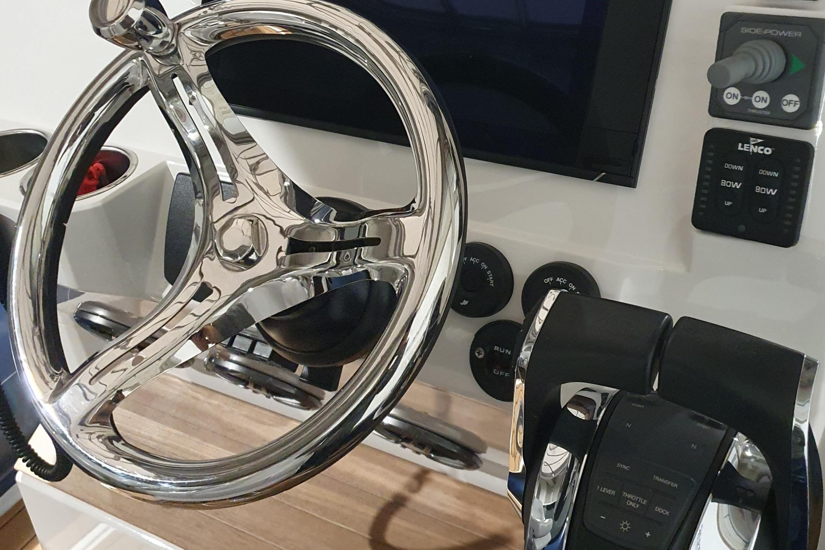 2023 Protector 330 boat helm with chrome steering wheel and control panel.