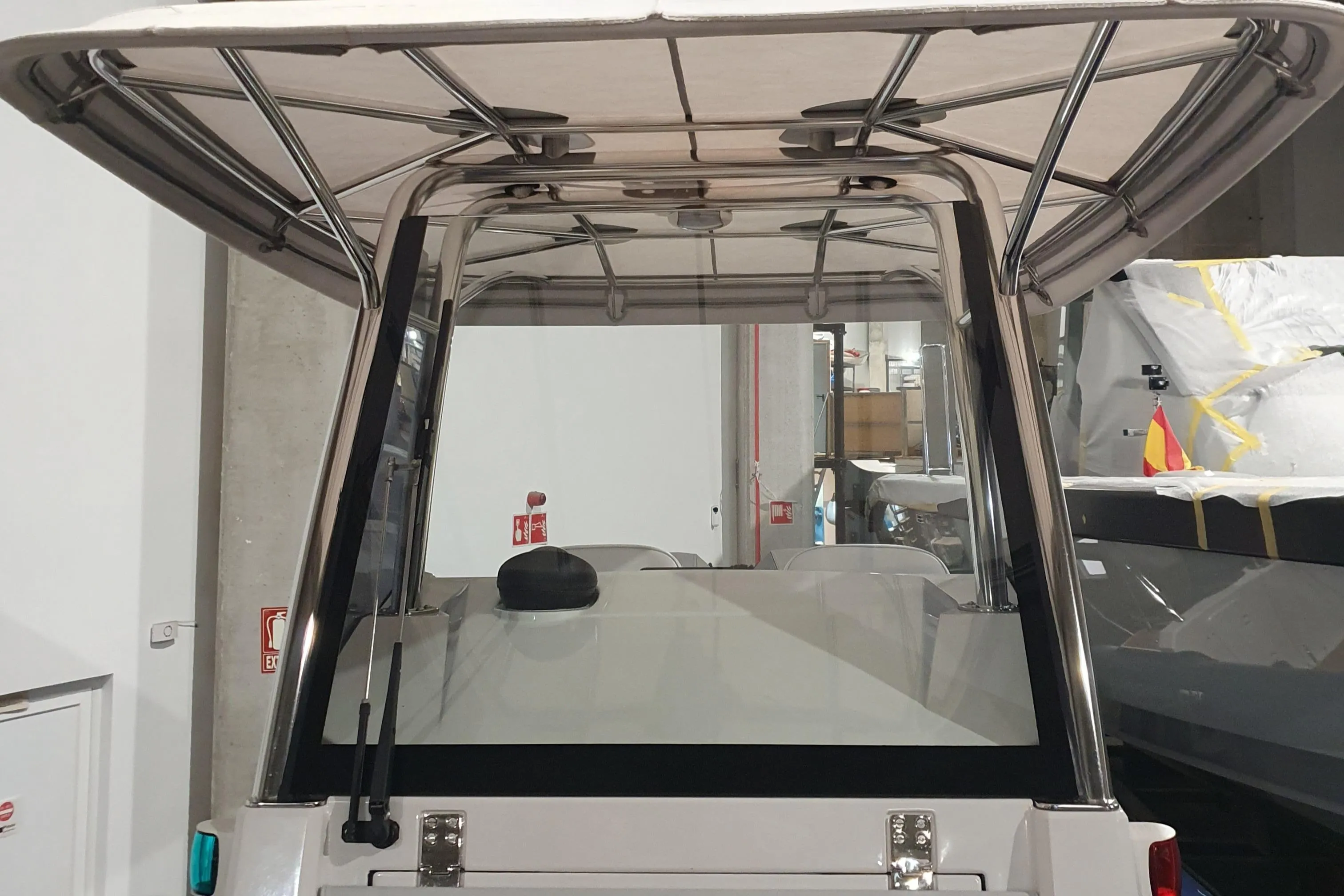 2023 Protector 330 boat with sturdy canopy and sleek design in a showroom.