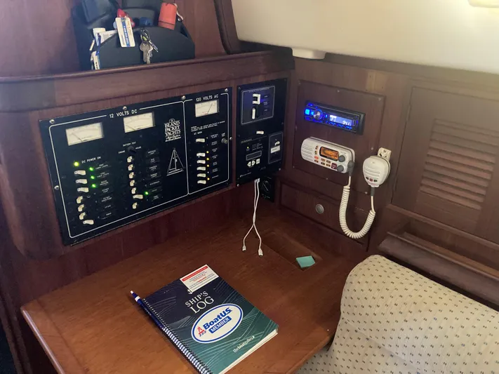 Enabled Yacht Photos Pics Navigation station of a 1999 Island Packet 350 sailboat with control panels and logbook.