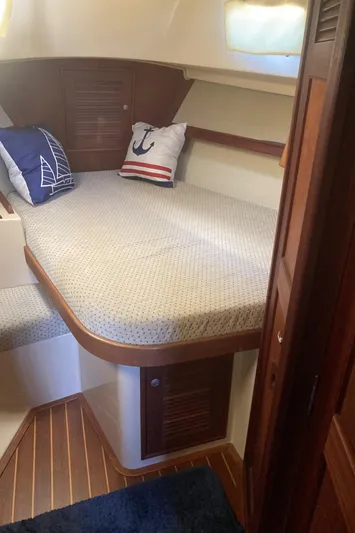 Enabled Yacht Photos Pics 1999 Island Packet 350 sailboat cabin with cozy bed and nautical-themed pillows.