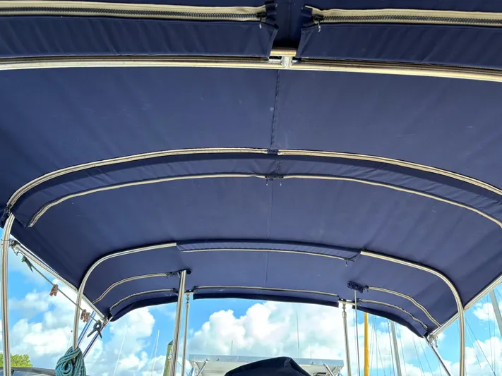 Enabled Yacht Photos Pics Blue canvas bimini top on 1999 Island Packet 350 sailboat, under clear sky.
