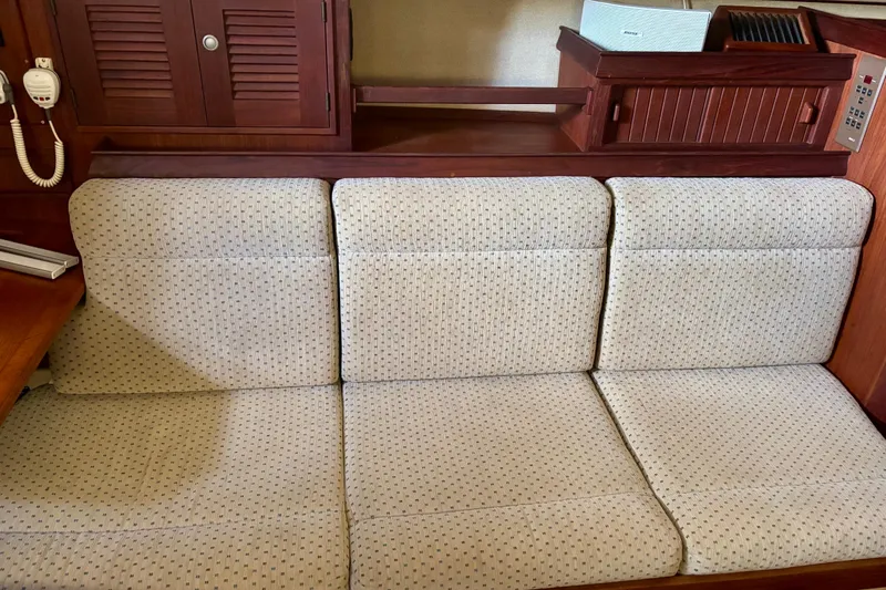 Enabled Yacht Photos Pics Interior of 1999 Island Packet 350 sailboat with cushioned seating and wooden cabinetry.