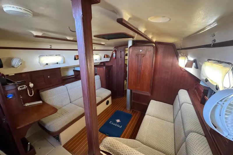 Enabled Yacht Photos Pics Interior of 1999 Island Packet 350 sailboat with cozy seating and wooden finishes.