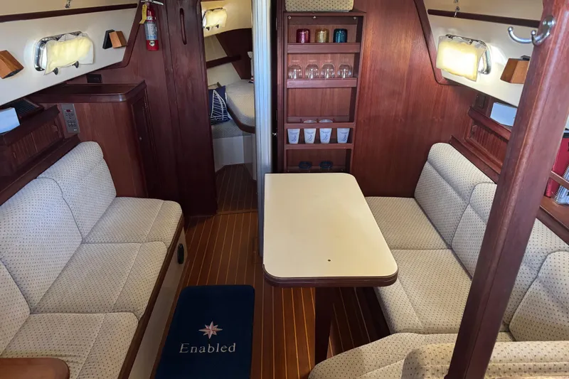 Enabled Yacht Photos Pics Interior of 1999 Island Packet 350 sailboat with cozy seating and wooden finishes.
