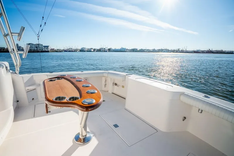 Moondawg Yacht Photos Pics 2007 Cabo 40 Express yacht deck with wooden table, overlooking serene water and sunny sky.