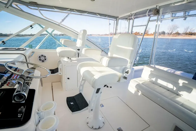 Moondawg Yacht Photos Pics 2007 Cabo 40 Express yacht interior with helm, white seating, and ocean view.