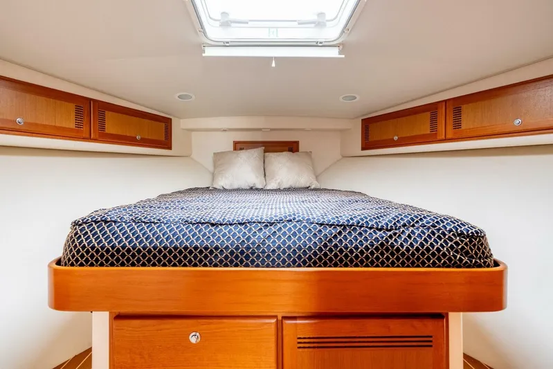 Moondawg Yacht Photos Pics Luxurious cabin interior of 2007 Cabo 40 Express yacht with cozy bed and wooden storage.